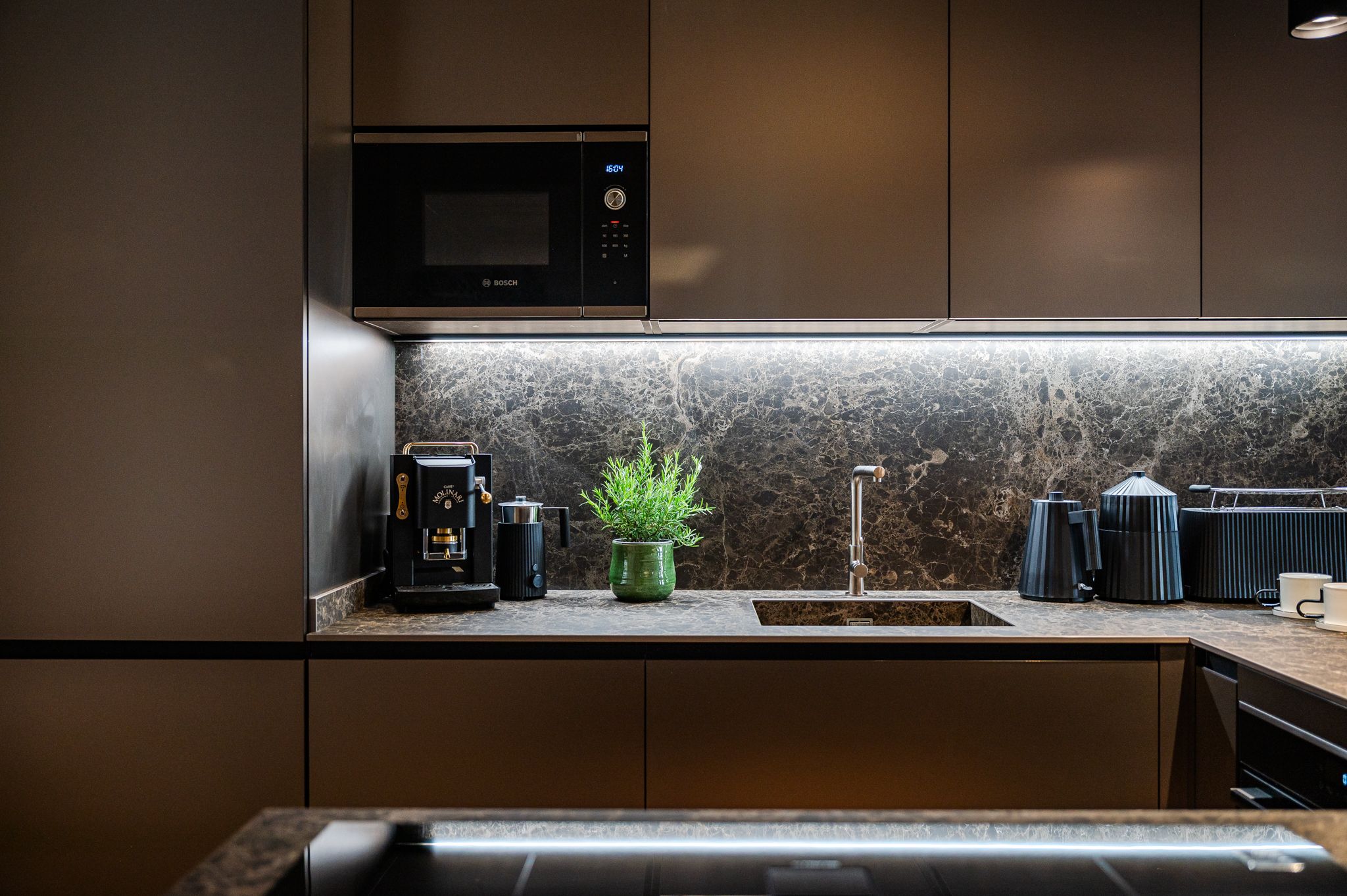 Evening-mood kitchen detail with illuminated marble backsplash