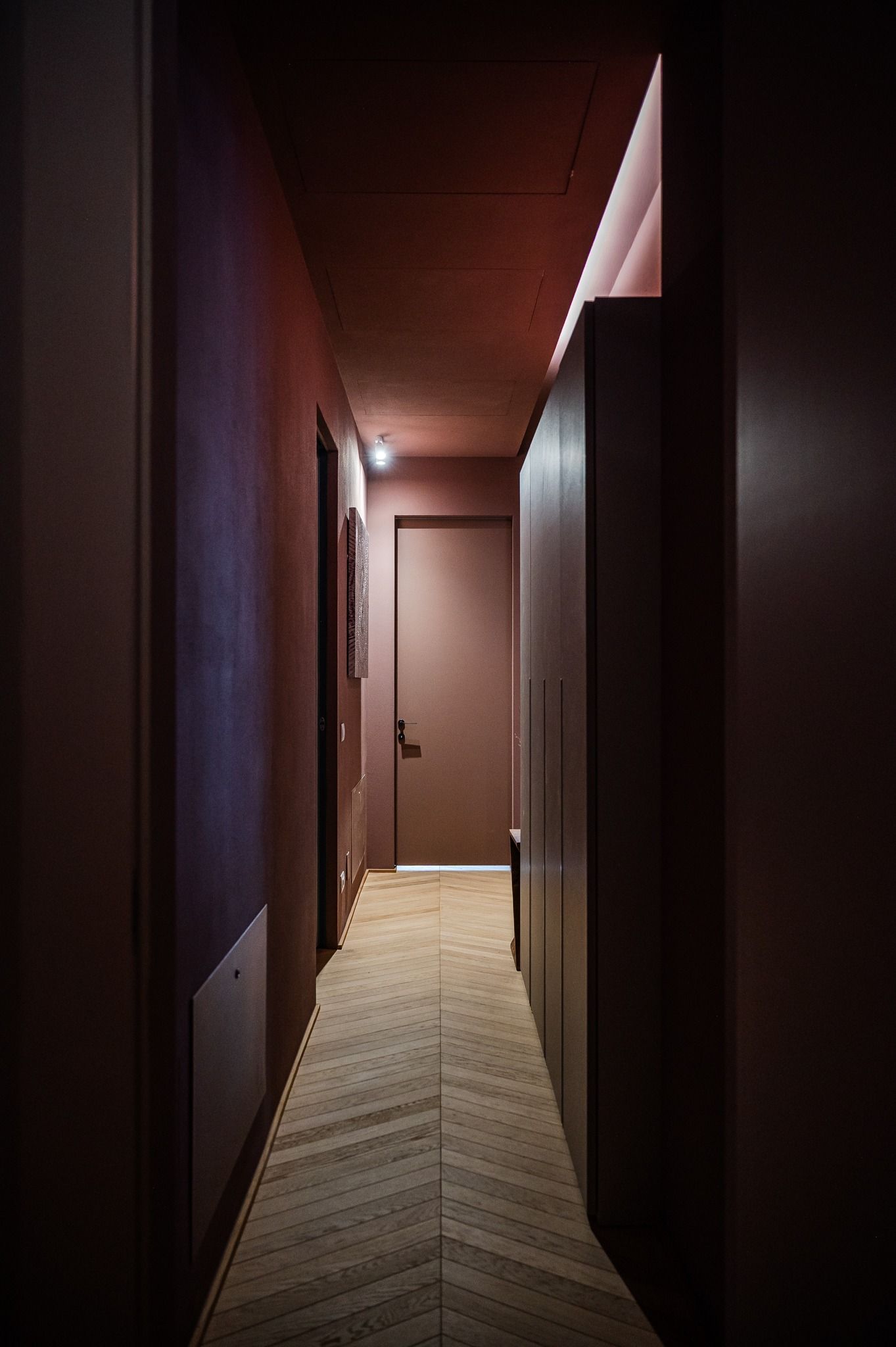 A dim corridor with herringbone parquet