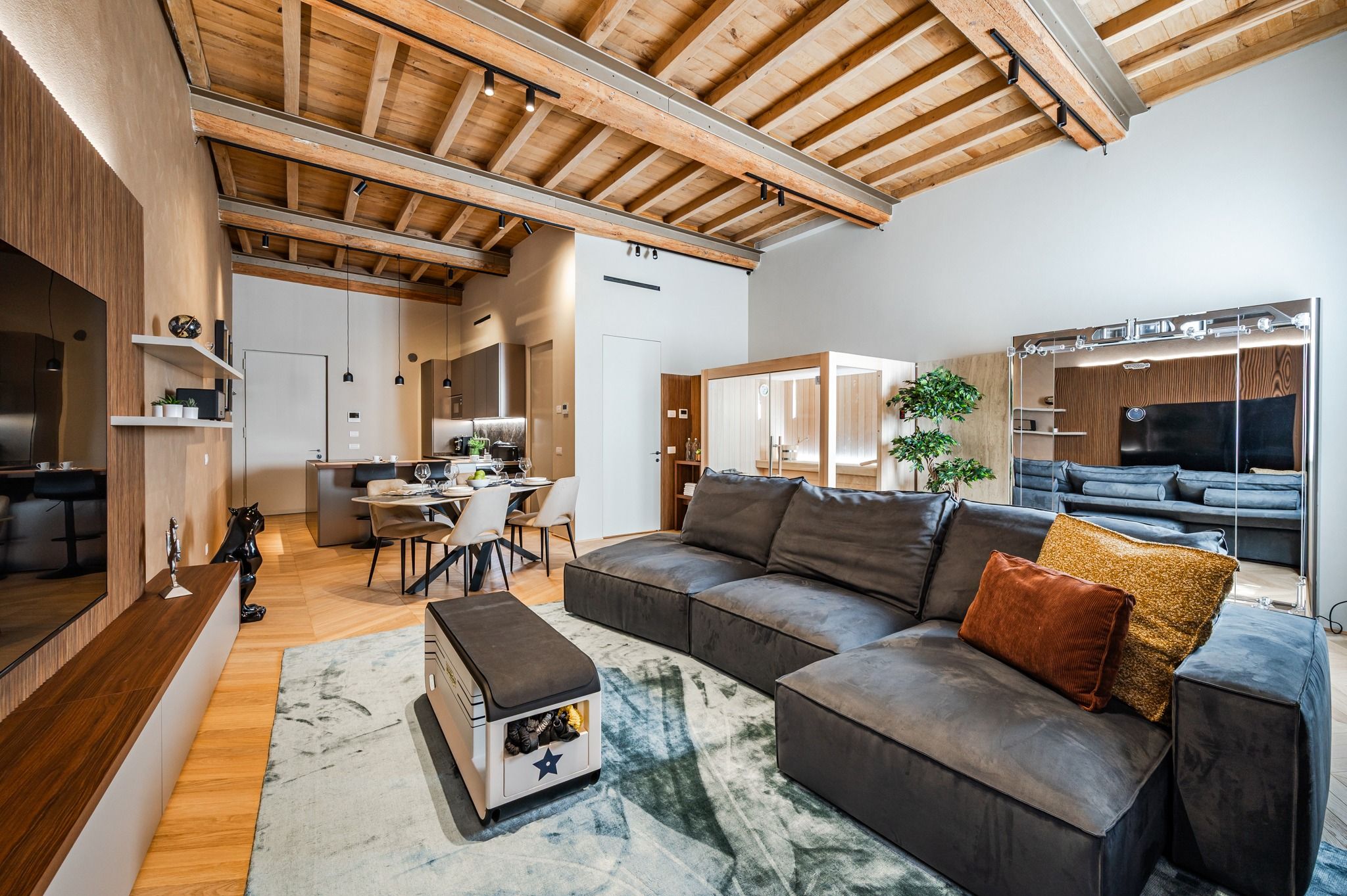 The full living room: sofa, set table and sauna in the background