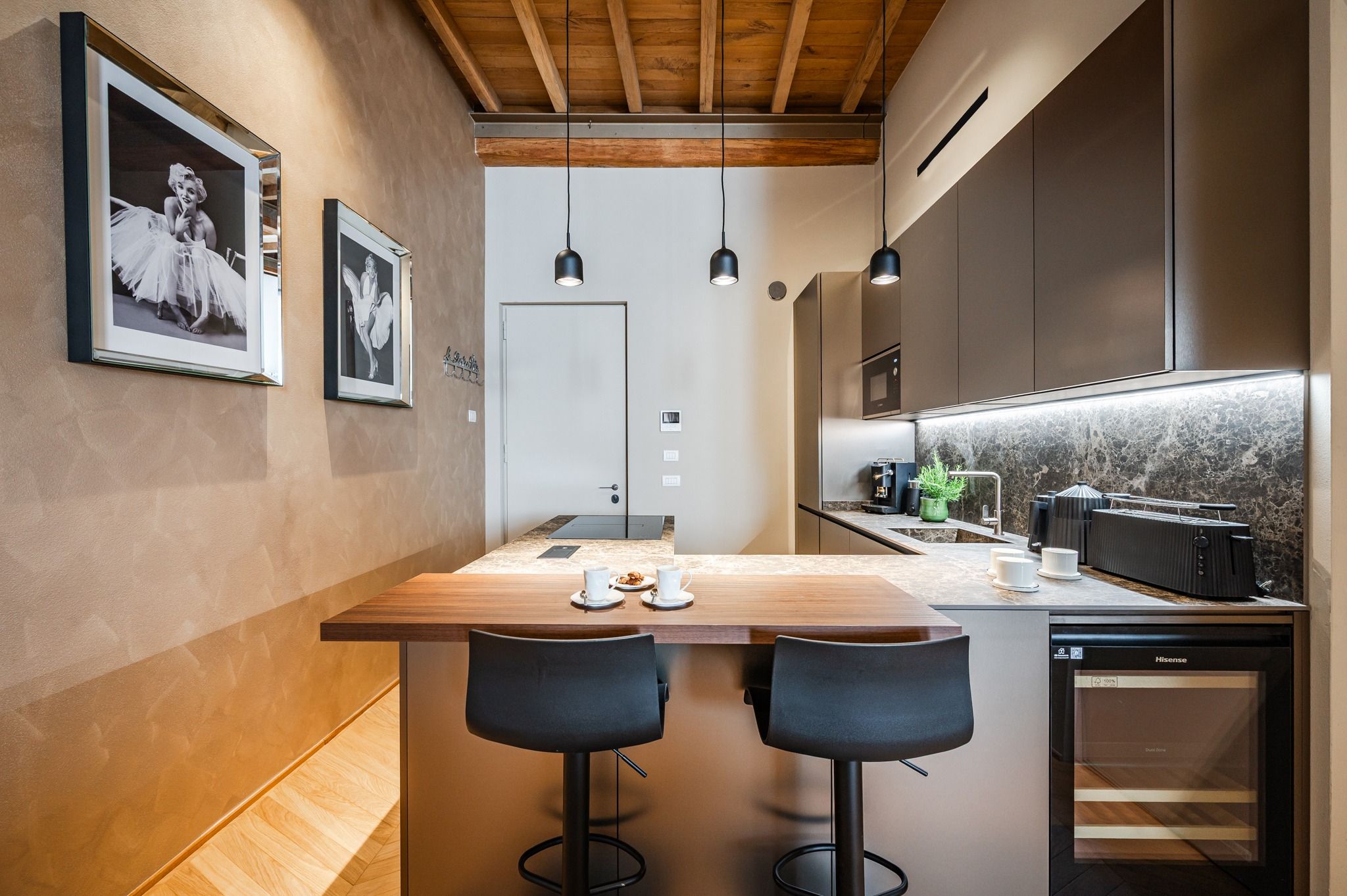 Kitchen corner with peninsula, stools and prints on the walls