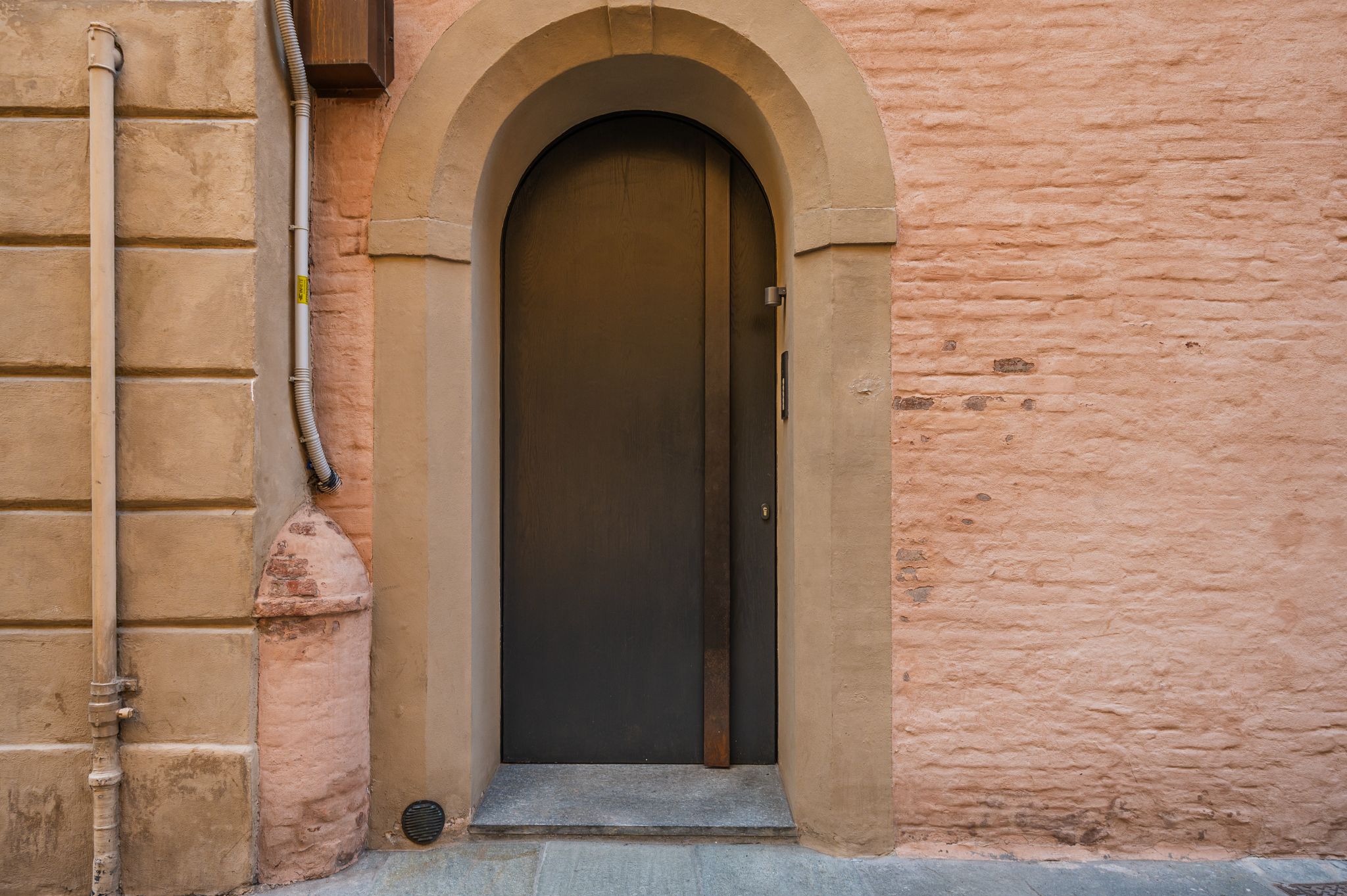 Portone d'ingresso su facciata color rosa nel centro storico